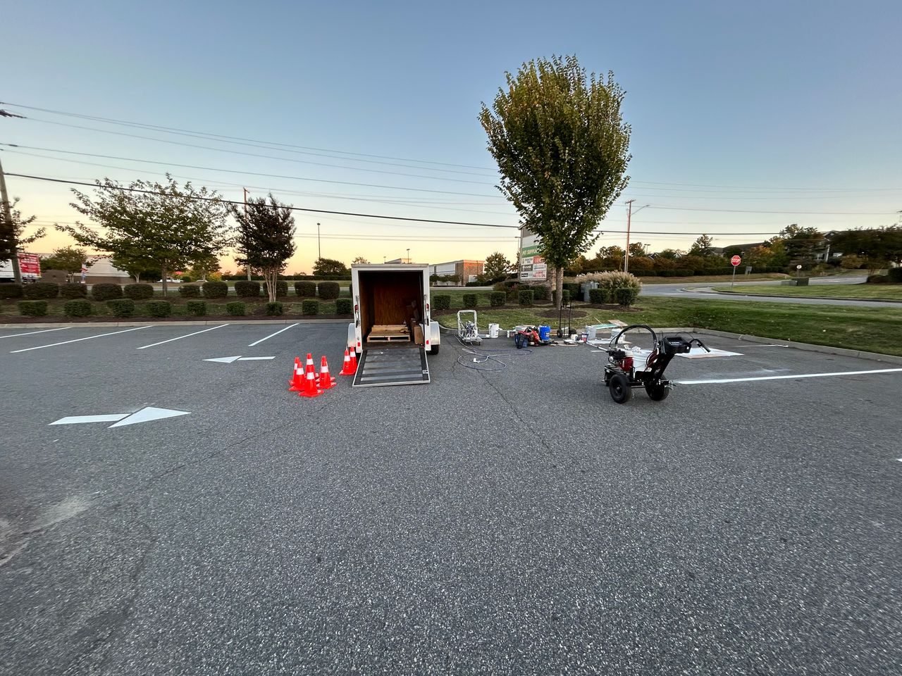 Fine Stripes crew and striping equipment set out with safety cones on a commercial parking lot