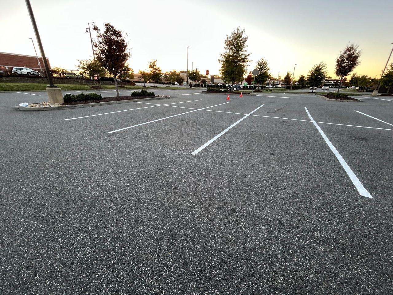 New white stall lines across an open parking lot in golden evening light