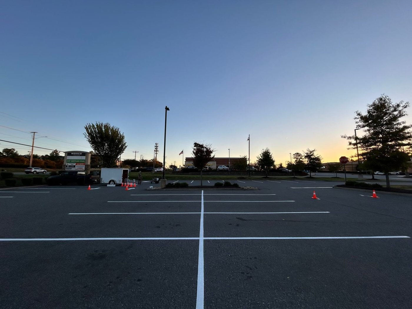 Long straight parking stall lines freshly painted across a commercial lot